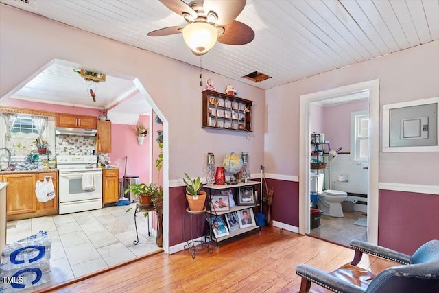 506 Currin St, Durham, NC 27703 - kitchen with white electric range, brown cabinetry, under cabinet range hood, electric panel, and a ceiling fan