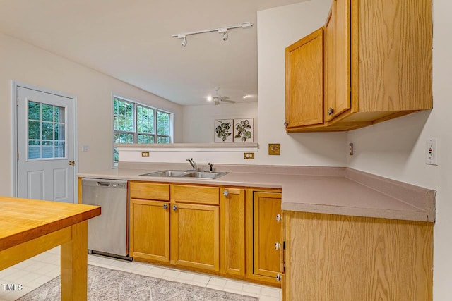 244 Sweet Bay Pl, Carrboro, NC 27510 - kitchen with stainless steel dishwasher, a sink, rail lighting, light countertops, and brown cabinetry