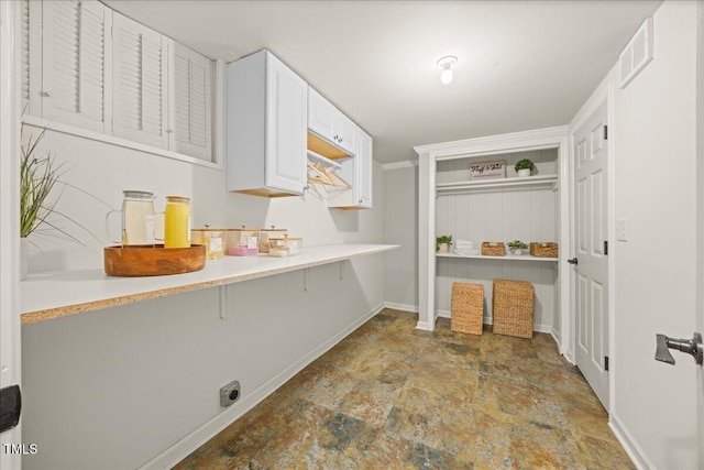 800 Camden Ave, Durham, NC 27701 - kitchen featuring stone finish floors, baseboards, white cabinets, a breakfast bar, and light countertops