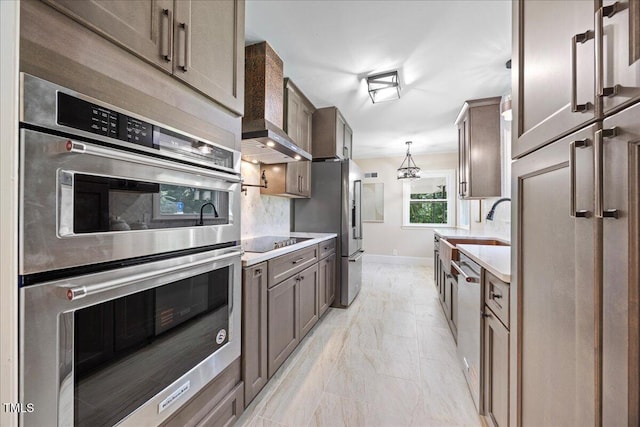800 Camden Ave, Durham, NC 27701 - kitchen featuring appliances with stainless steel finishes, wall chimney range hood, backsplash, and light marble finish floors