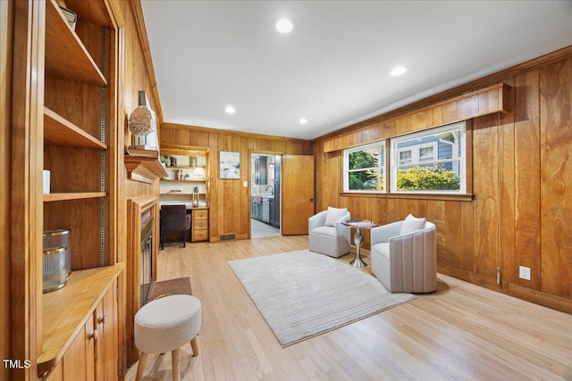800 Camden Ave, Durham, NC 27701 - living room featuring a fireplace, light wood-style flooring, wooden walls, recessed lighting, and crown molding