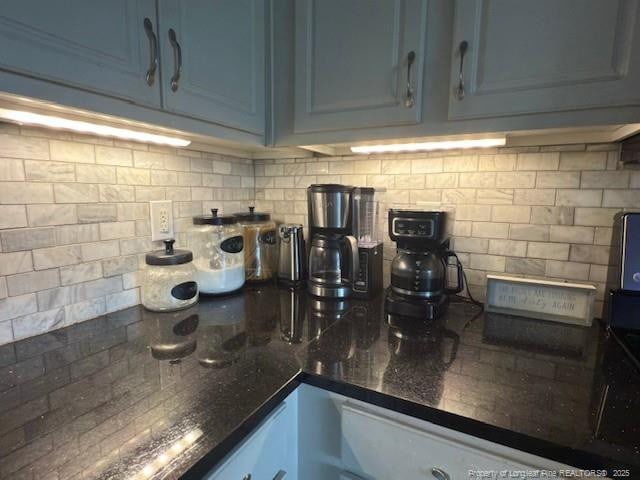 5516 Hall Glen Dr, Hope Mills, NC 28348 - kitchen view of tasteful backsplash, dark stone countertops, and blue cabinets