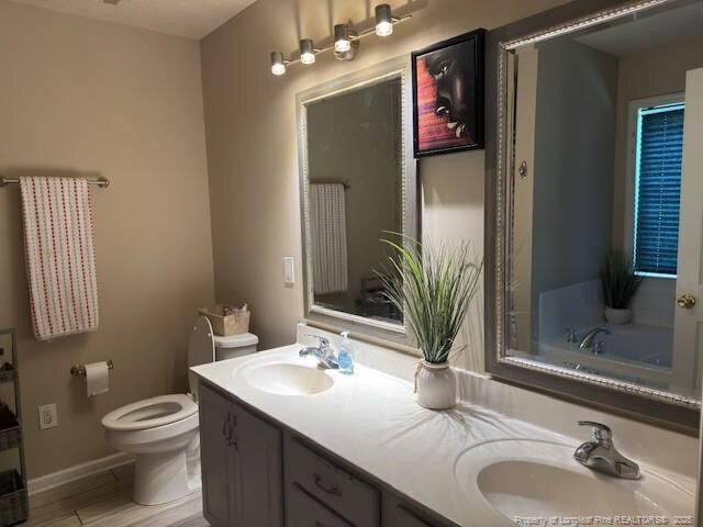 5516 Hall Glen Dr, Hope Mills, NC 28348 - bathroom with double vanity, wood finished floors, and a tub