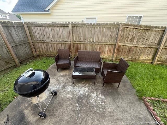 5516 Hall Glen Dr, Hope Mills, NC 28348 - fenced backyard featuring an outdoor hangout area and a patio