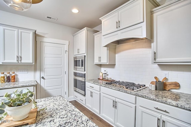 554 Beacon Ridge Blvd, Chapel Hill, NC 27516 - kitchen with appliances with stainless steel finishes, backsplash, light stone counters, wood finished floors, and recessed lighting