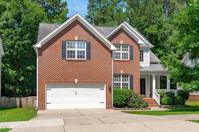 4804 Carmen Ln, Durham, NC 27707 - traditional-style house featuring concrete driveway, an attached garage, a standing seam roof, covered porch, and brick siding