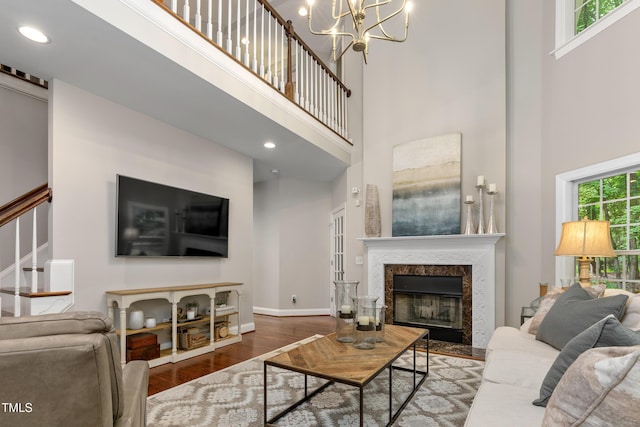 603 Edburton Ct, Hillsborough, NC 27278 - living room featuring a high ceiling, wood finished floors, a fireplace, stairs, and a chandelier