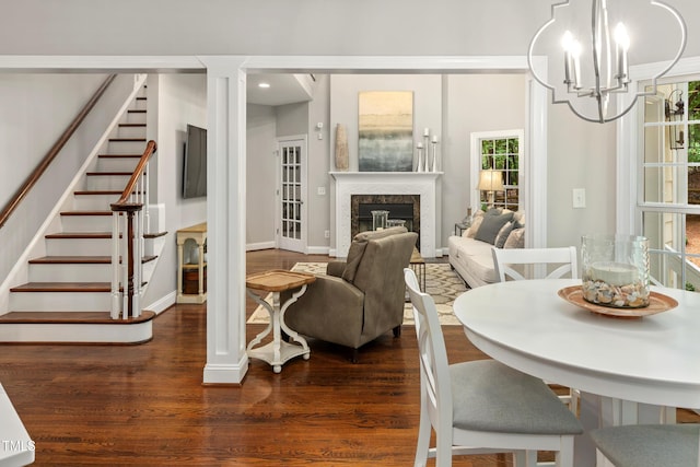 603 Edburton Ct, Hillsborough, NC 27278 - dining area with dark wood-style floors, stairs, a chandelier, a premium fireplace, and decorative columns