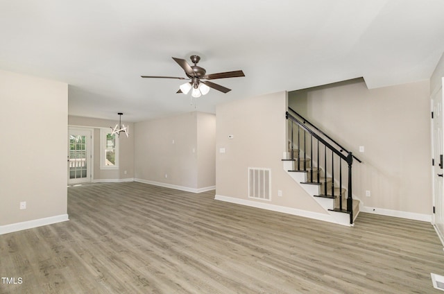 2324 Dahlgreen Rd, Raleigh, NC 27615 - unfurnished living room with a ceiling fan, a chandelier, light wood-style floors, and stairs