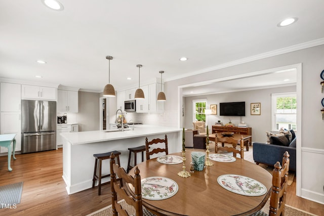 433 Rosehaven Dr, Raleigh, NC 27609 - dining area featuring light wood finished floors, crown molding, and recessed lighting