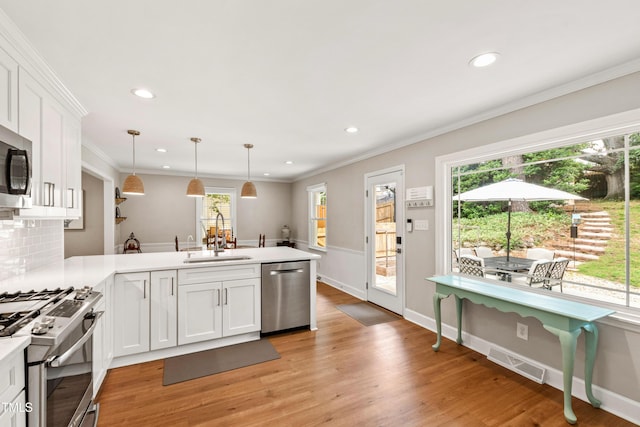 433 Rosehaven Dr, Raleigh, NC 27609 - kitchen featuring appliances with stainless steel finishes, a peninsula, white cabinetry, recessed lighting, and light countertops