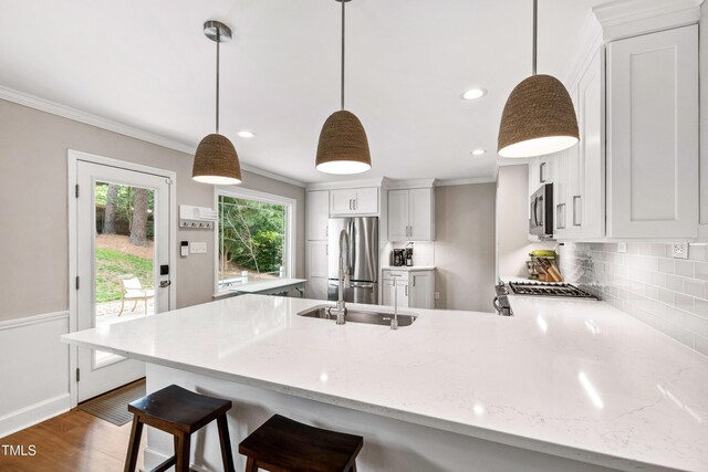 433 Rosehaven Dr, Raleigh, NC 27609 - kitchen with appliances with stainless steel finishes, ornamental molding, a peninsula, decorative backsplash, and light stone counters