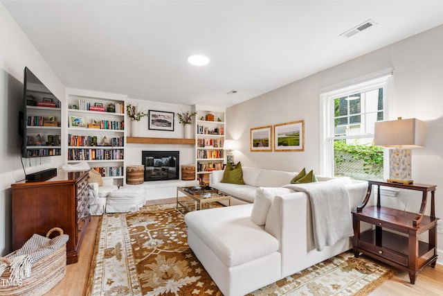 433 Rosehaven Dr, Raleigh, NC 27609 - living room with wood finished floors, a glass covered fireplace, and recessed lighting