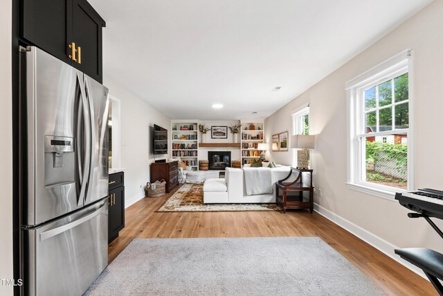 433 Rosehaven Dr, Raleigh, NC 27609 - living room with light wood finished floors and a glass covered fireplace
