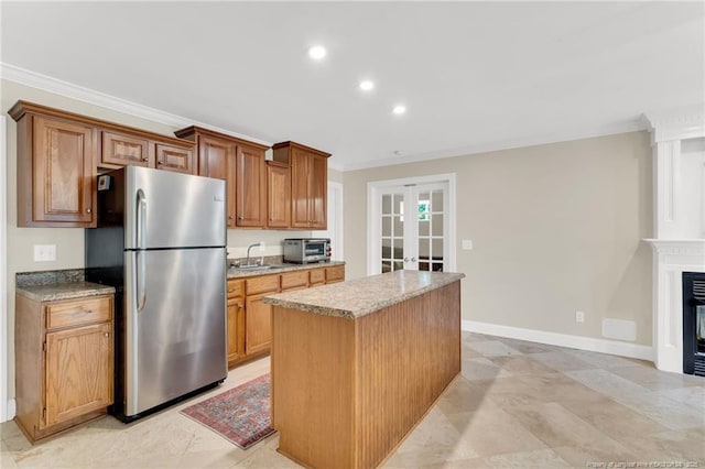 6558 Countryside Dr, Fayetteville, NC 28311 - kitchen featuring freestanding refrigerator, french doors, ornamental molding, a center island, and a sink