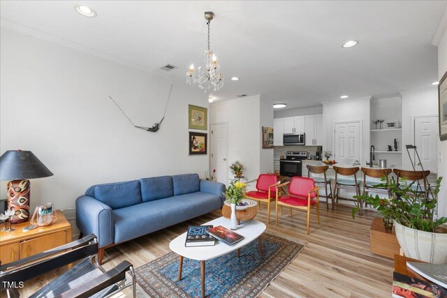 800 Savannah Ridge Rd Unit 109, Holly Springs, NC 27540 - living area with a chandelier, light wood-style floors, recessed lighting, and crown molding