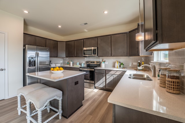 303 Enfield Dr, Carthage, NC 28327 - kitchen featuring appliances with stainless steel finishes, a sink, dark brown cabinets, a kitchen island, and backsplash