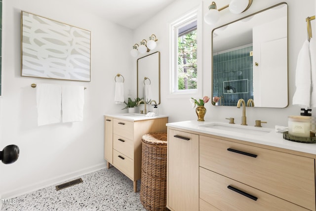 939 Clarion Dr, Durham, NC 27705 - full bathroom featuring speckle patterned floor, two vanities, and a tile shower