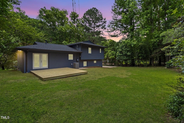 939 Clarion Dr, Durham, NC 27705 - back of property at dusk featuring french doors, a lawn, and a deck