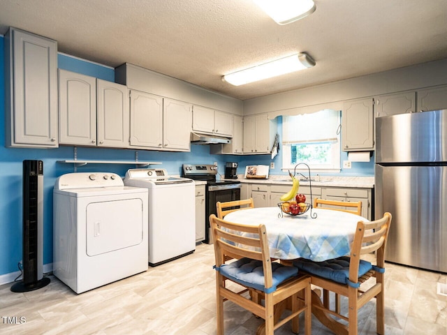 203 Lane Of Sir Kay, Garner, NC 27529 - kitchen featuring stainless steel appliances, separate washer and dryer, under cabinet range hood, light countertops, and a textured ceiling