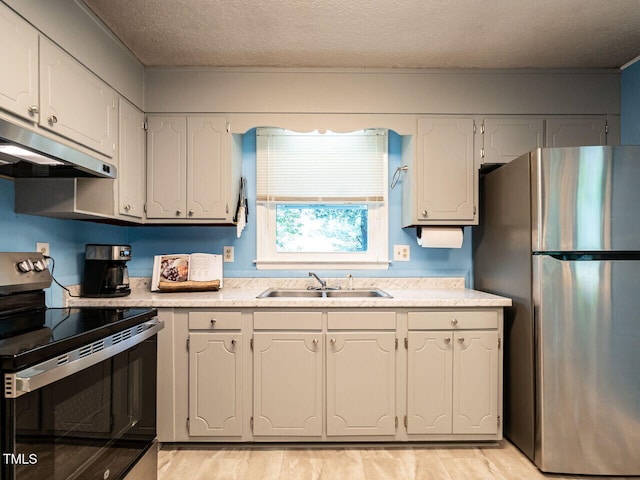 203 Lane Of Sir Kay, Garner, NC 27529 - kitchen featuring stainless steel appliances, under cabinet range hood, light countertops, light wood-style flooring, and a textured ceiling