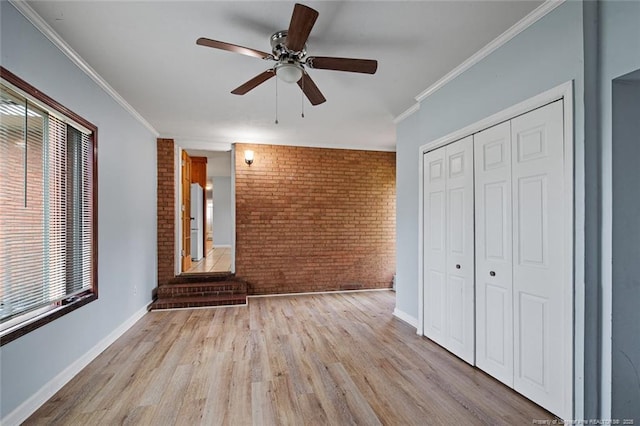 6425 Morganton Rd, Fayetteville, NC 28314 - unfurnished living room featuring brick wall, wood finished floors, ceiling fan, crown molding, and baseboards