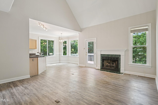 316 Trafalgar Ln, Cary, NC 27513 - unfurnished living room with healthy amount of natural light, a fireplace, wood finished floors, and high vaulted ceiling