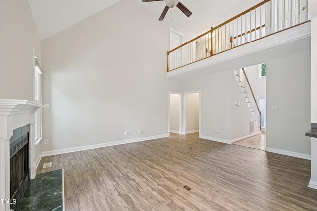 316 Trafalgar Ln, Cary, NC 27513 - unfurnished living room featuring high vaulted ceiling, a ceiling fan, stairway, wood finished floors, and a fireplace