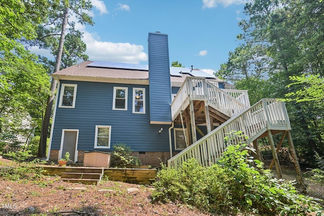 316 Trafalgar Ln, Cary, NC 27513 - back of house with stairway, a chimney, solar panels, a wooden deck, and roof with shingles