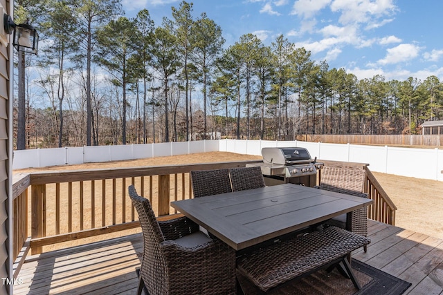 40 Ironwood Blvd, Youngsville, NC 27596 - wooden deck featuring a grill, outdoor dining area, a fenced backyard, and view of scattered trees