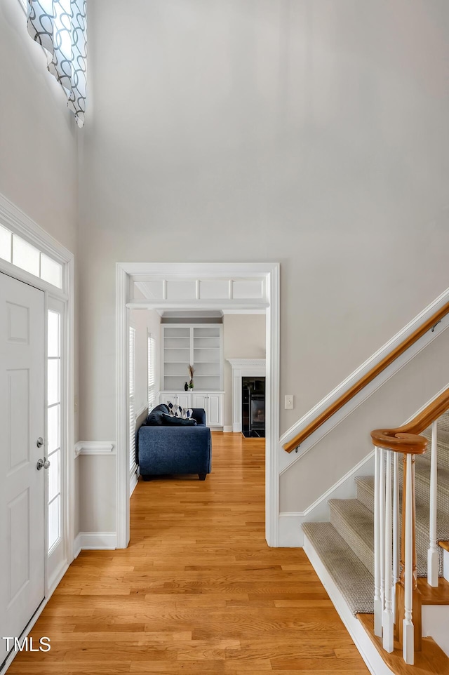 100 Highfield Ave, Cary, NC 27519 - entrance foyer with light wood finished floors, stairway, a towering ceiling, and a fireplace with flush hearth