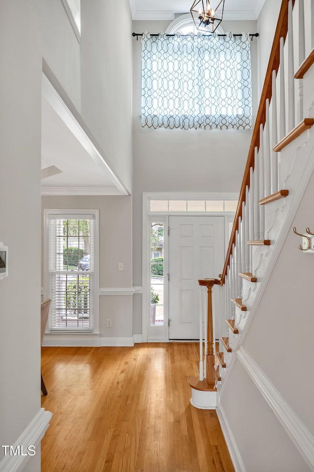 100 Highfield Ave, Cary, NC 27519 - entrance foyer with a chandelier, stairway, wood finished floors, a towering ceiling, and crown molding