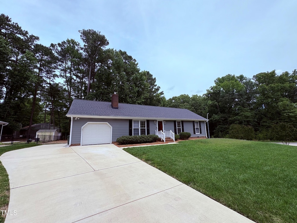 100 Honeysuckle Ln, Cary, NC 27513 - single story home with concrete driveway, a garage, a chimney, and a front lawn