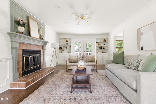 16 Cedar Hill Dr, Durham, NC 27713 - living area with built in shelves, wood finished floors, a tiled fireplace, crown molding, and a chandelier