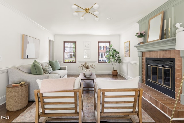 16 Cedar Hill Dr, Durham, NC 27713 - living room featuring wood finished floors, a tiled fireplace, crown molding, a wainscoted wall, and a decorative wall