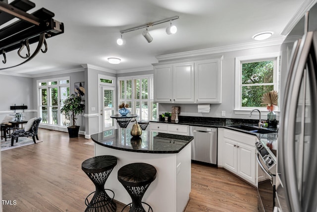 12 Gatesway Ct, Durham, NC 27707 - kitchen featuring appliances with stainless steel finishes, white cabinetry, light wood-style floors, ornamental molding, and a breakfast bar