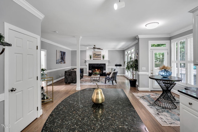 12 Gatesway Ct, Durham, NC 27707 - living room featuring a high end fireplace, ornamental molding, wood finished floors, ceiling fan, and decorative columns