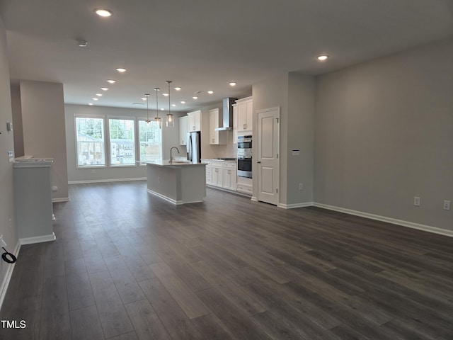 2203 Lambert Rd Unit 67, Cary, NC 27519 - kitchen featuring stainless steel appliances, wall chimney exhaust hood, a sink, a kitchen island with sink, and open floor plan