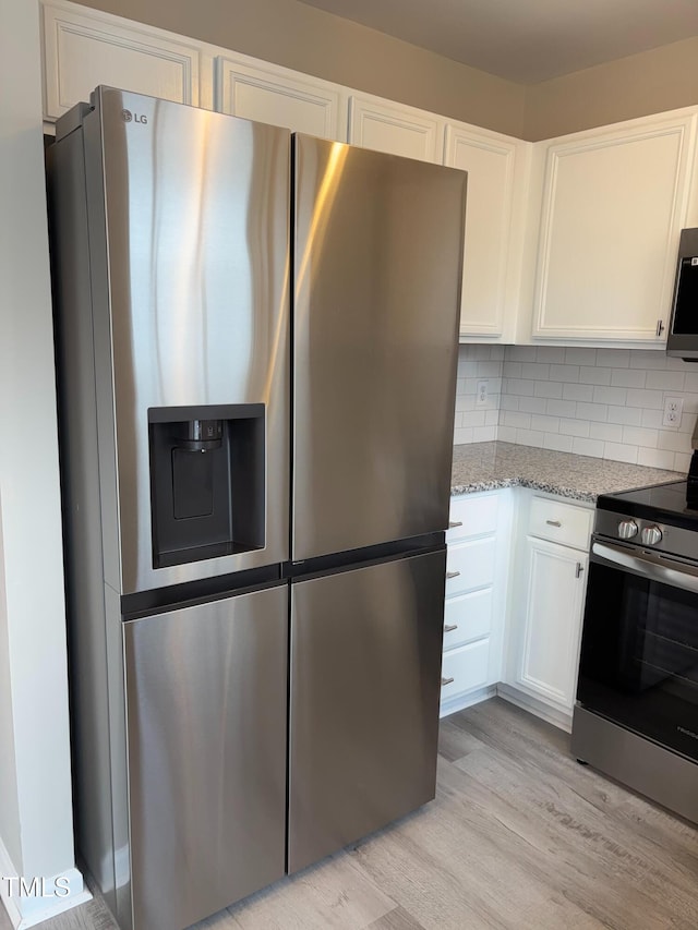 7710 River Field Dr, Raleigh, NC 27616 - kitchen featuring stainless steel appliances, white cabinets, light wood-style flooring, light stone countertops, and tasteful backsplash