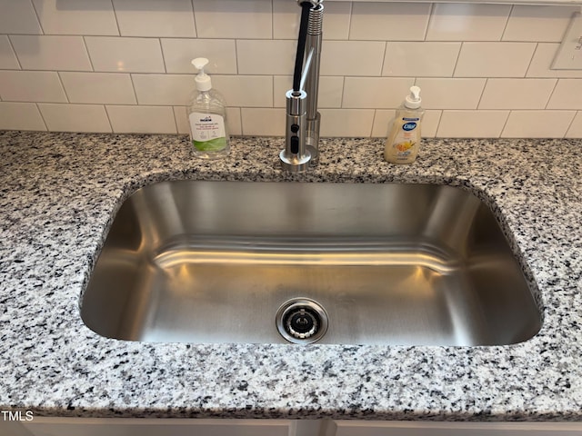 7710 River Field Dr, Raleigh, NC 27616 - kitchen view of a sink, light stone counters, and decorative backsplash