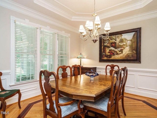 8504 Carlton Oaks Dr, Wake Forest, NC 27587 - dining area with light wood-style flooring, a chandelier, ornamental molding, a raised ceiling, and a decorative wall