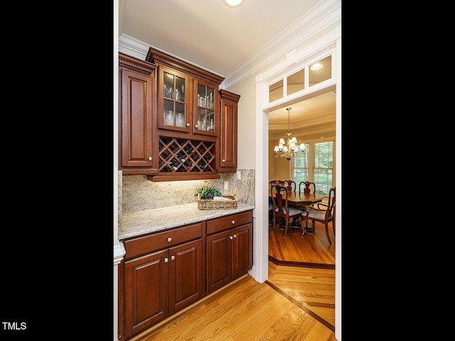 8504 Carlton Oaks Dr, Wake Forest, NC 27587 - bar featuring ornamental molding, backsplash, a chandelier, and light wood-style flooring