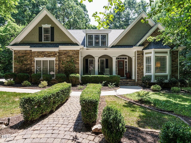8504 Carlton Oaks Dr, Wake Forest, NC 27587 - craftsman house featuring stone siding, a porch, and a shingled roof