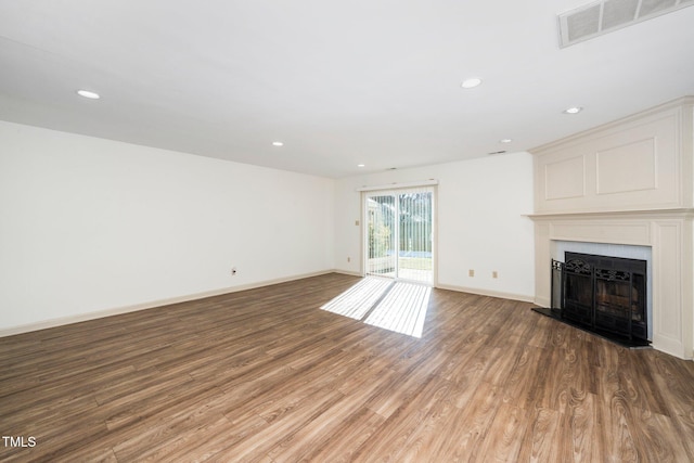 1505 Clermont Rd Unit 15, Durham, NC 27713 - unfurnished living room with wood finished floors, a fireplace with raised hearth, recessed lighting, and baseboards