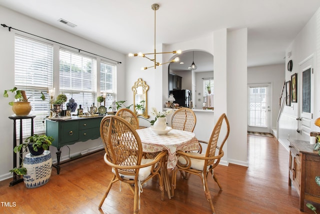 818 Bryant St, Raleigh, NC 27603 - dining space with wood finished floors, healthy amount of natural light, arched walkways, and a chandelier