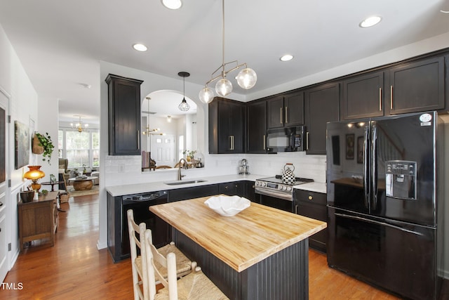 818 Bryant St, Raleigh, NC 27603 - kitchen with black appliances, tasteful backsplash, light wood-type flooring, hanging light fixtures, and recessed lighting