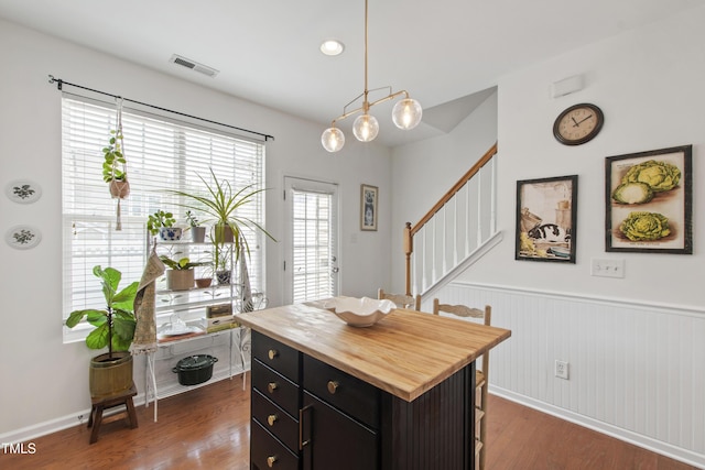 818 Bryant St, Raleigh, NC 27603 - kitchen with wooden counters, a wainscoted wall, a kitchen bar, dark wood-type flooring, and pendant lighting
