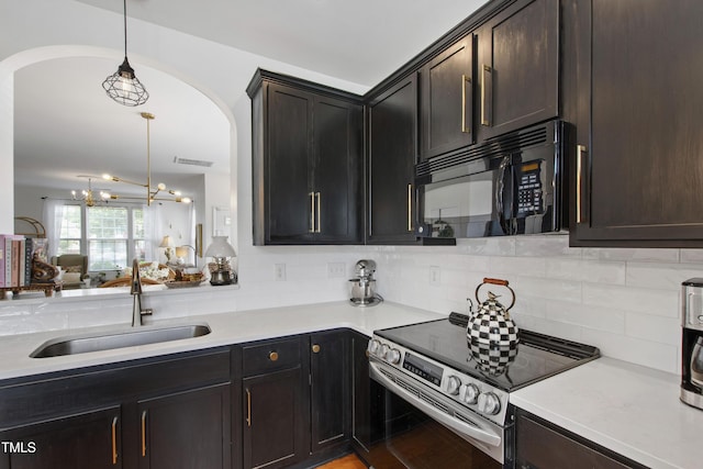 818 Bryant St, Raleigh, NC 27603 - kitchen with black microwave, stainless steel electric range, arched walkways, backsplash, and light countertops