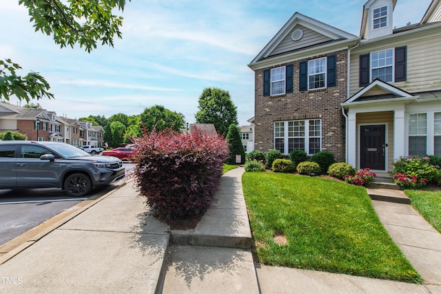 818 Bryant St, Raleigh, NC 27603 - view of front facade with a front yard, uncovered parking, brick siding, and a residential view