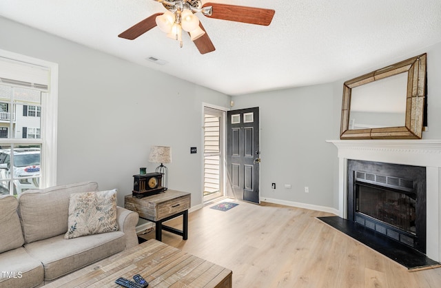 2600 Dwight Pl, Raleigh, NC 27610 - living area with wood finished floors, ceiling fan, a fireplace with flush hearth, and a textured ceiling